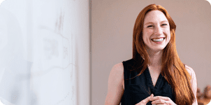 Smiling woman presenting at whiteboard