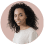 Smiling person with curly hair on pastel background.